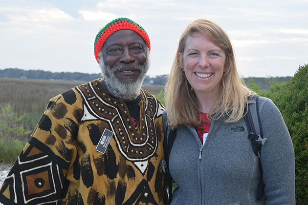 a man and a woman pose with a mountain landscape in the background