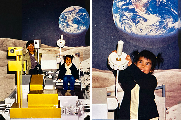 Composite image of a female child exploring a space-themed exhibit that simulates the lunar surface, featuring a gold and white lunar rover model with control instruments. A large image of Earth from space is displayed in the background, creating an immersive moon landing experience.