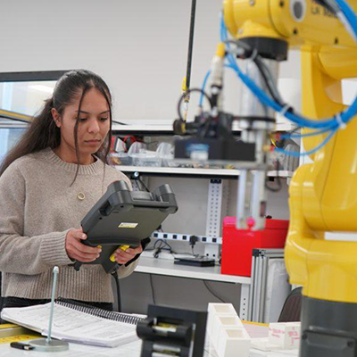 female researcher working in the lab with a large yellow piece of equipment