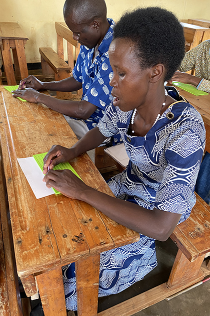 Students with blindness at the Masaka Resource Center writing in Braille using a slate and stylus.
