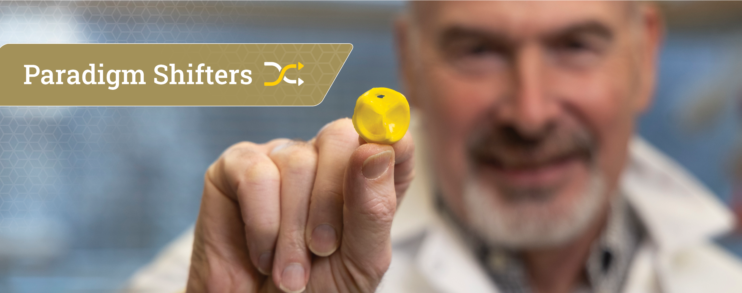 male researcher holding the raw material for a 3D printed yellow heart valve in his hand