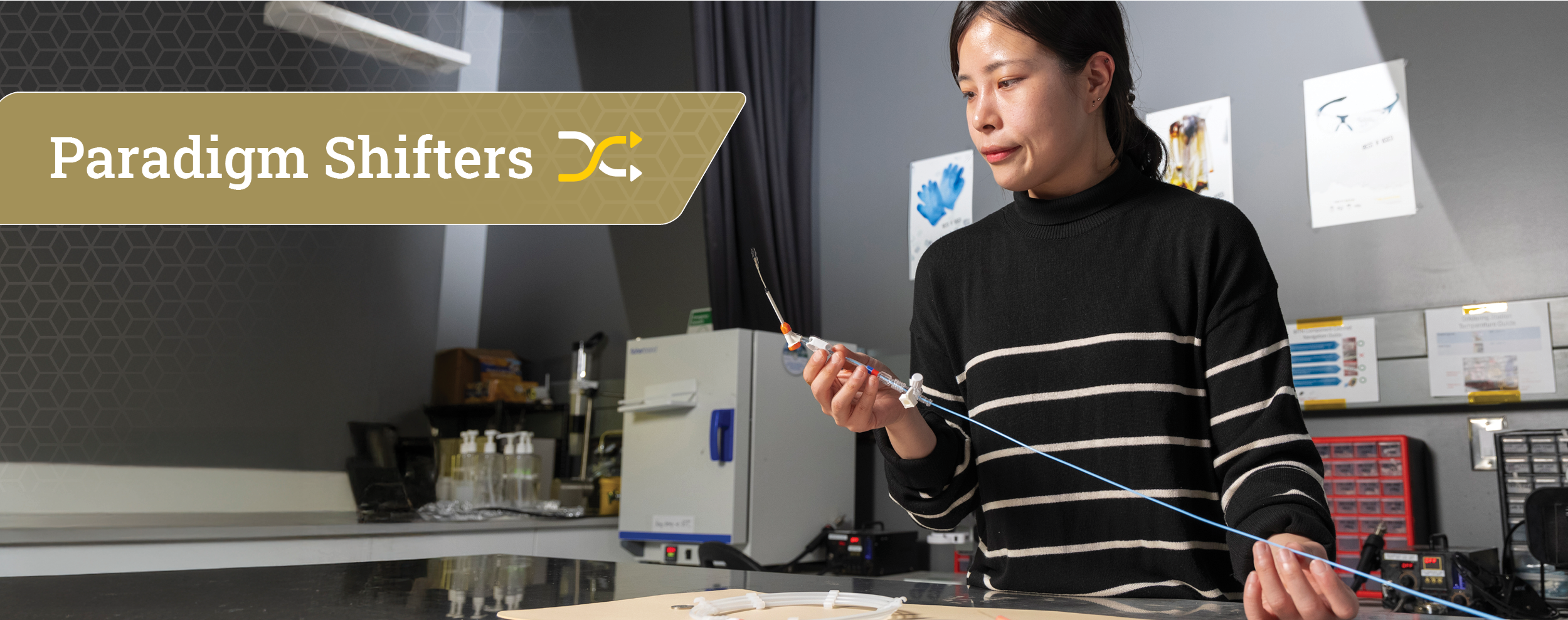 female researcher in a lab holding a small sensor