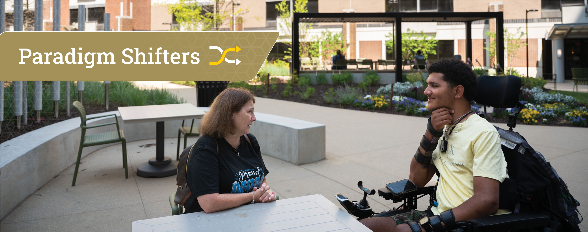 Two people talking in a garden a women and man in a mechanized wheelchair