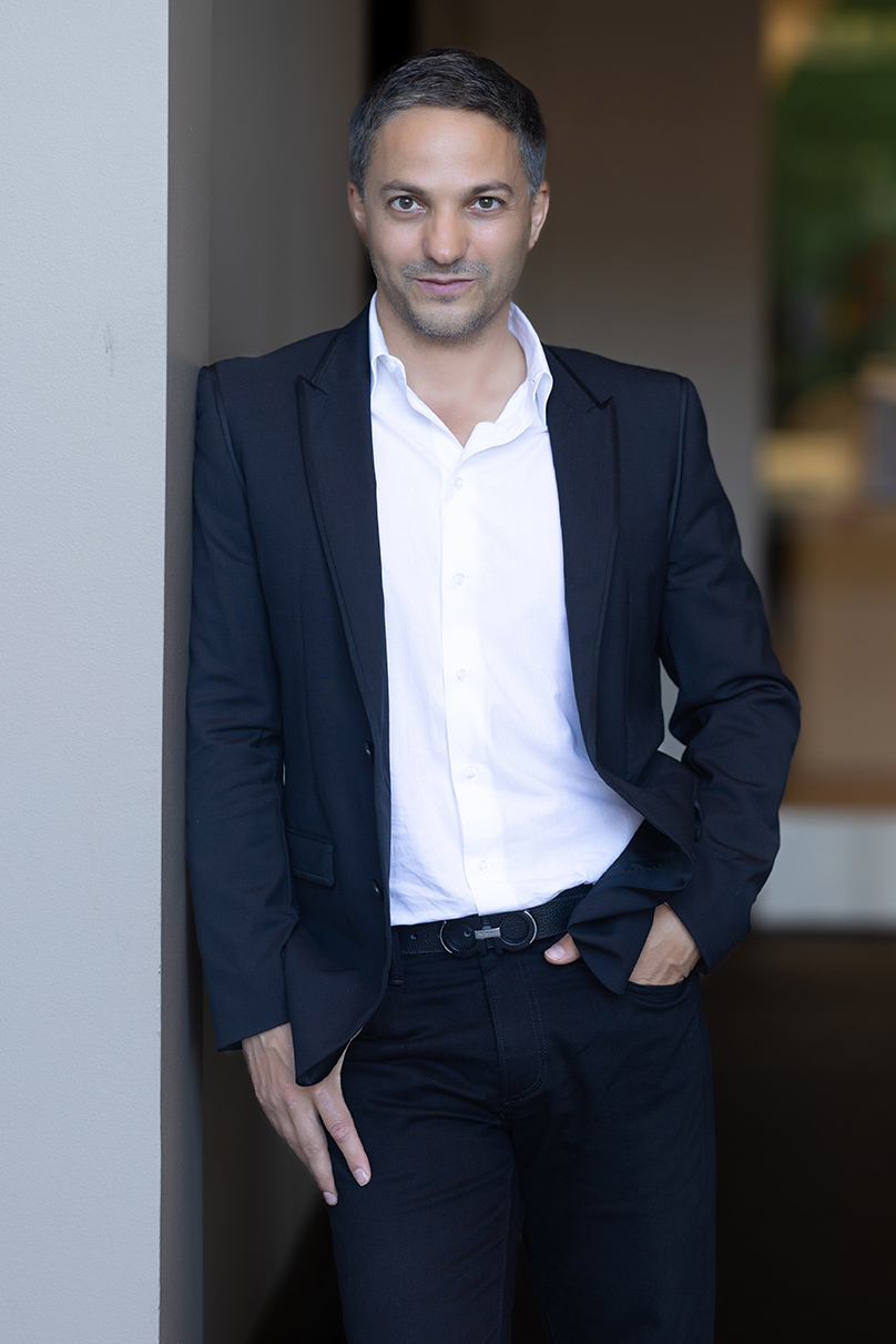 /Gleb%20Yushin%20leaning%20on%20a%20wall.%20