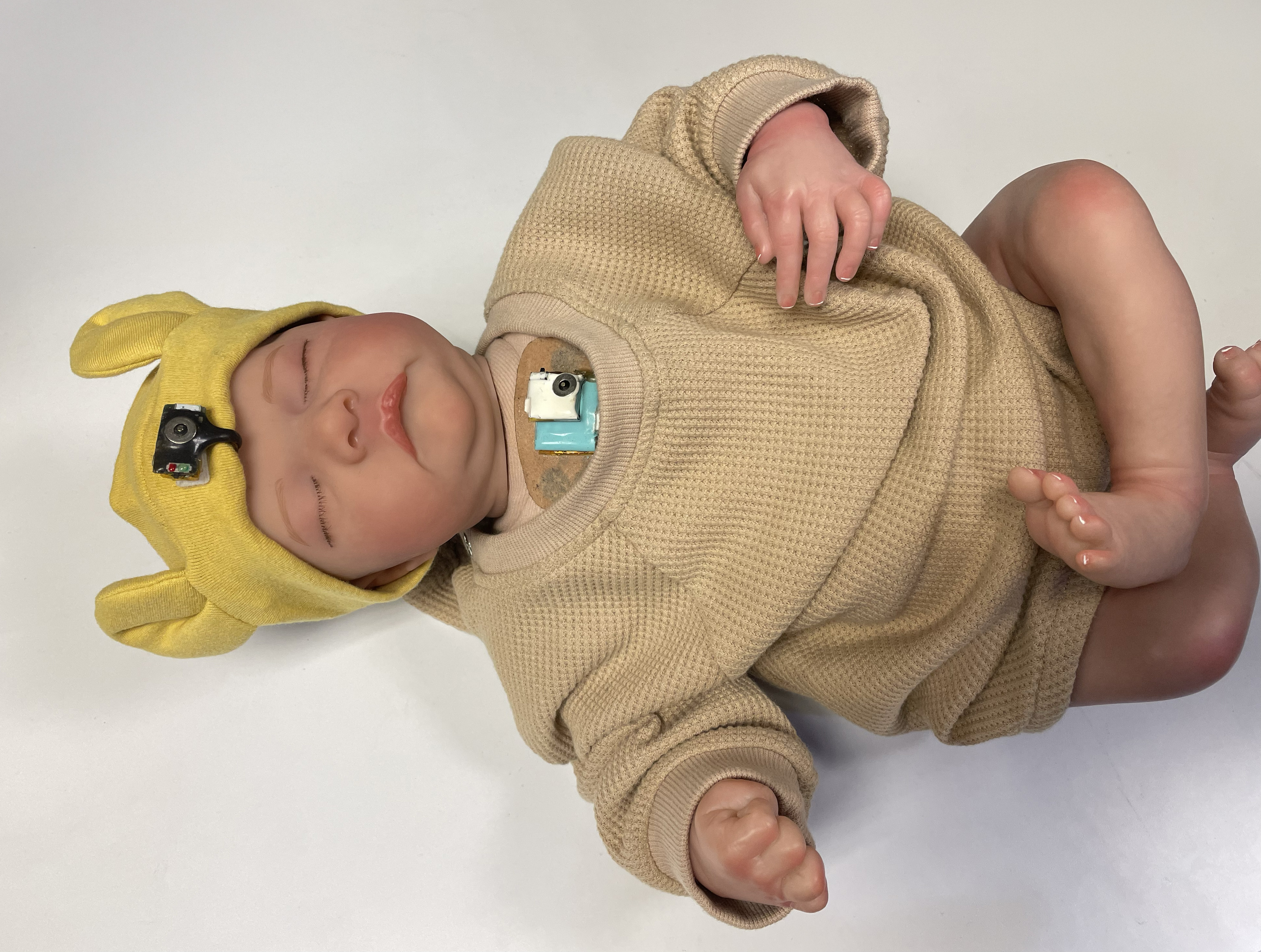 /Wearable%20chest-mounted%20patch%20and%20forehead-mounted%20pulse%20oximeter%20shown%20on%20a%20mannequin%20baby%20for%20illustration