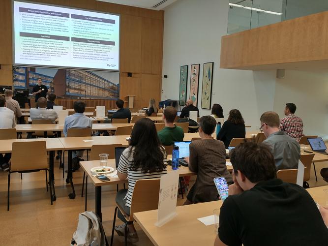 Researchers gather to hear each other's lightning talks.