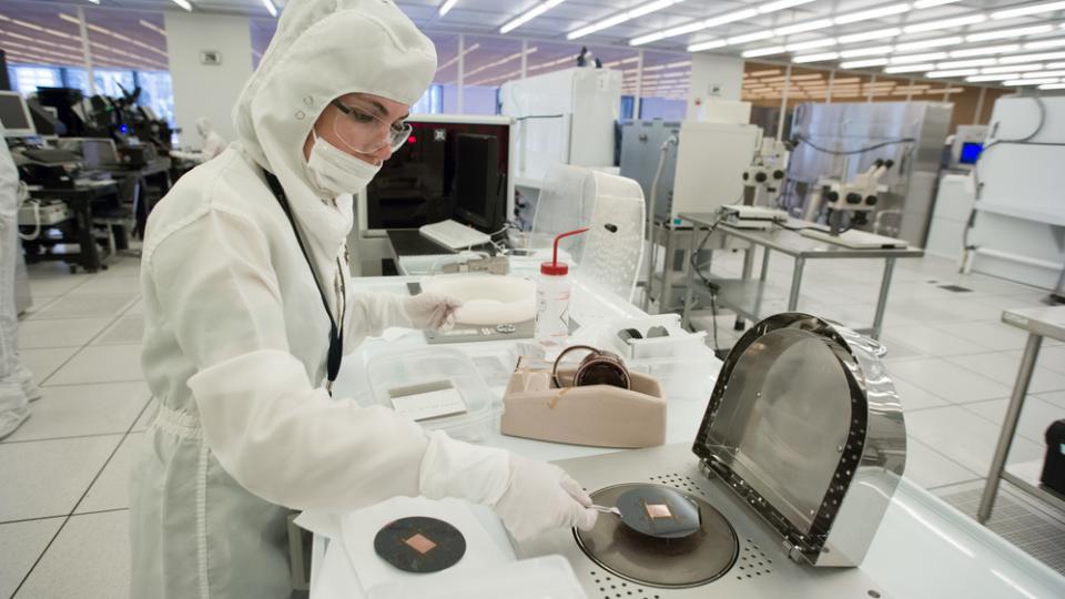A scientist dressed in protective clothing works in a clean room laboratory at Georgia Tech