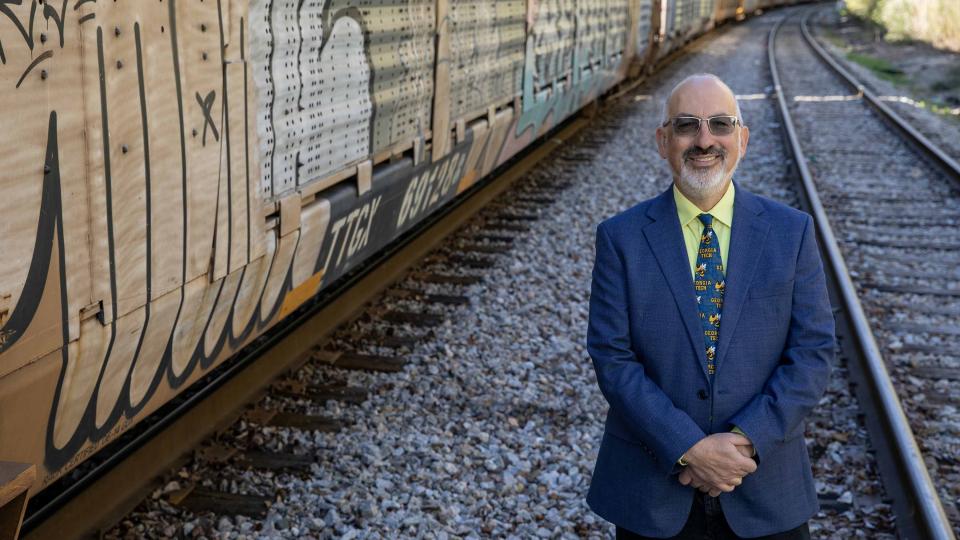Railroads are key components of the nation’s critical infrastructure. Jeremy Epstein poses with rail cars on a siding. (Credit: Sean McNeil, GTRI)