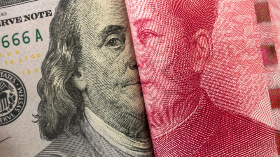 America dollar and Yuan banknote with USA and China flags.