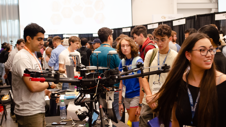 At booths, Georgia Tech founders showcase their new products to a crowded exhibition hall with people from the Georgia Tech community, as well as the public and business community.