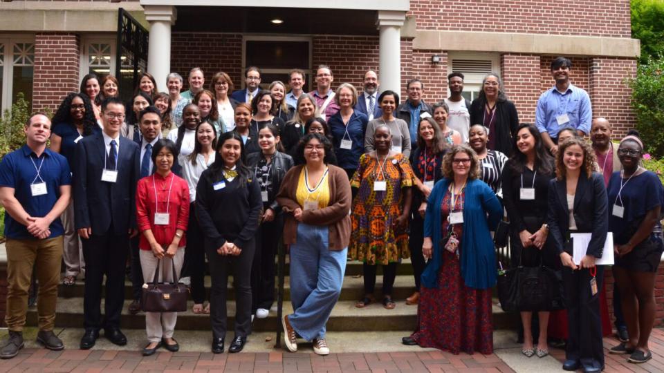A group of attendees to the RCE Americas meeting in Atlanta pose for a group photo outside a red brick Georgia Tech building.