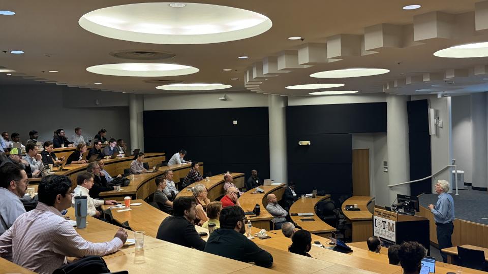 Andrew Dugenske, a principal research engineer at GTMI and symposium organizer, delivering a talk at the symposium's tenth annual gathering.