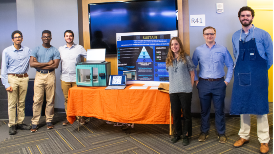 Team Sustain poses with their lock box for home cooked meals at the 2024 Spring Capstone Expo.