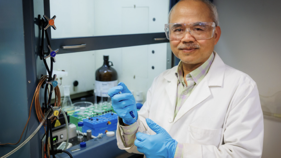 Photo of Rallming Yang in a lab holding a syringe 