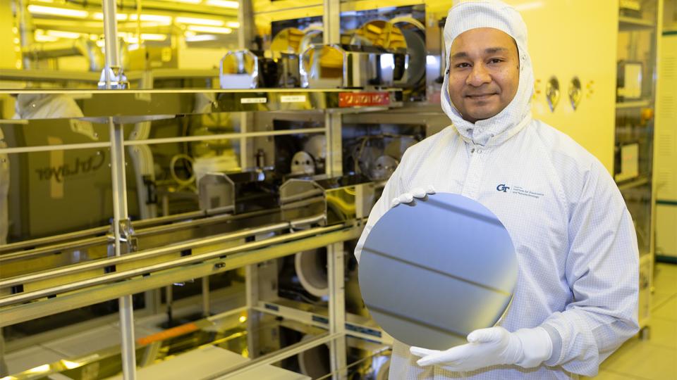 Asif Khan holds a silicon wafer in a cleanroom.