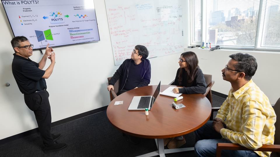 Rampi Ramprasad and three members of his research team discuss their AI model for generative polymer design in his office.