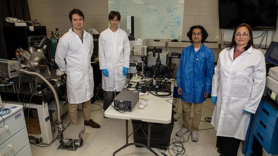 Four GTRI researchers pose for a photo in a lab space. 