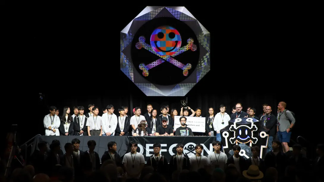 Team Atlanta stands on the dark DefCon stage during the convention's closing ceremony. 