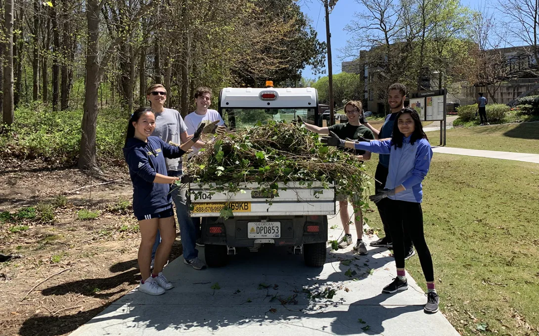 Students remove ivy from an area near The Kendeda Building for Innovative Sustainable Design in April 2022.
