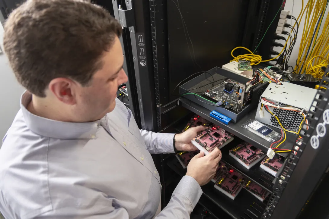 A man holds a PYNQ-Z2 development boards used for FPGA (Field-Programmable Gate Array) development. 