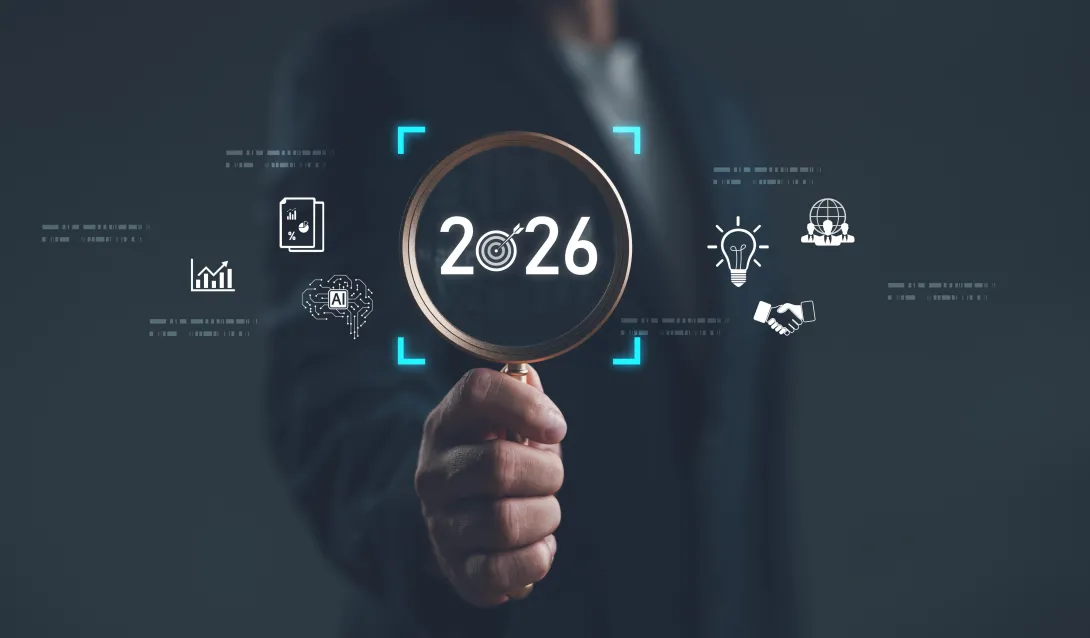 Businessman holding magnifying glass focusing on year 2026 with digital icons of innovation, AI, analytics, and global strategy. Concept of future planning, technology trends and vision. 