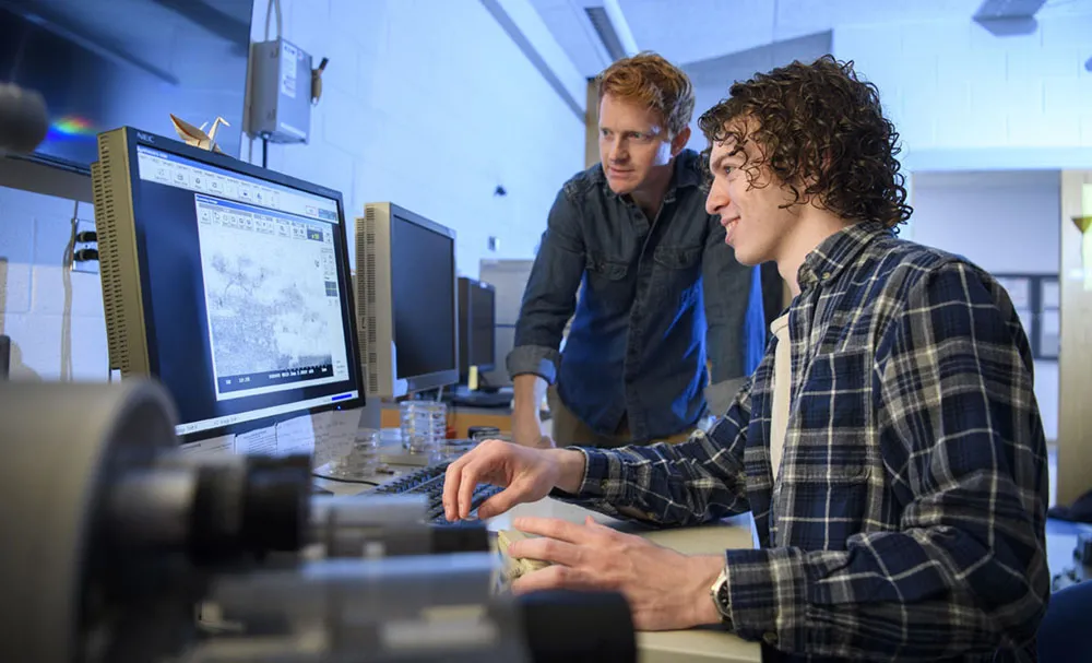 Berry College student Jacob Sylvie and his advisor Zack Lindsey working at a materials imaging tool