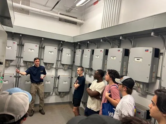 Rich Simmons, giving a tour of the inverter room in the CNES building to the student volunteers 