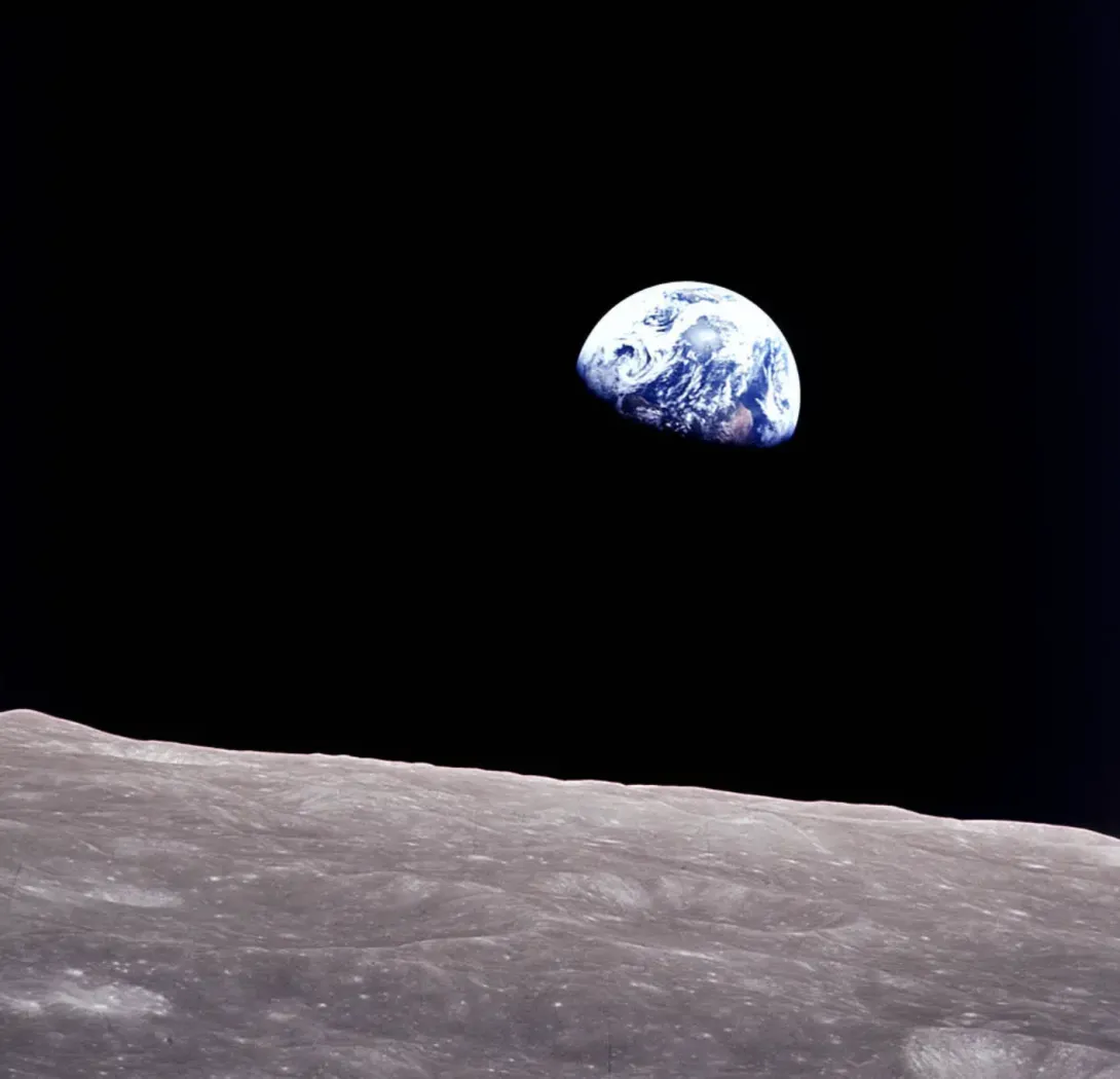 Earth peeking out from beyond the lunar surface.