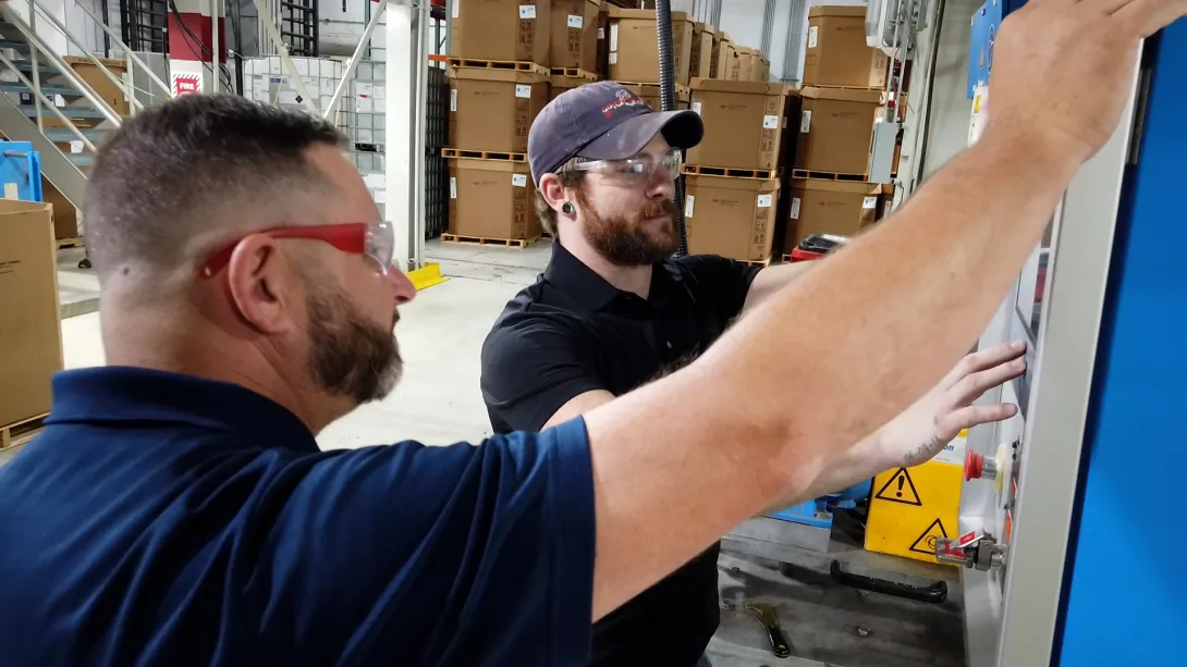 This image shows technicians at Silon working a monitoring screen at their manufacturing facility